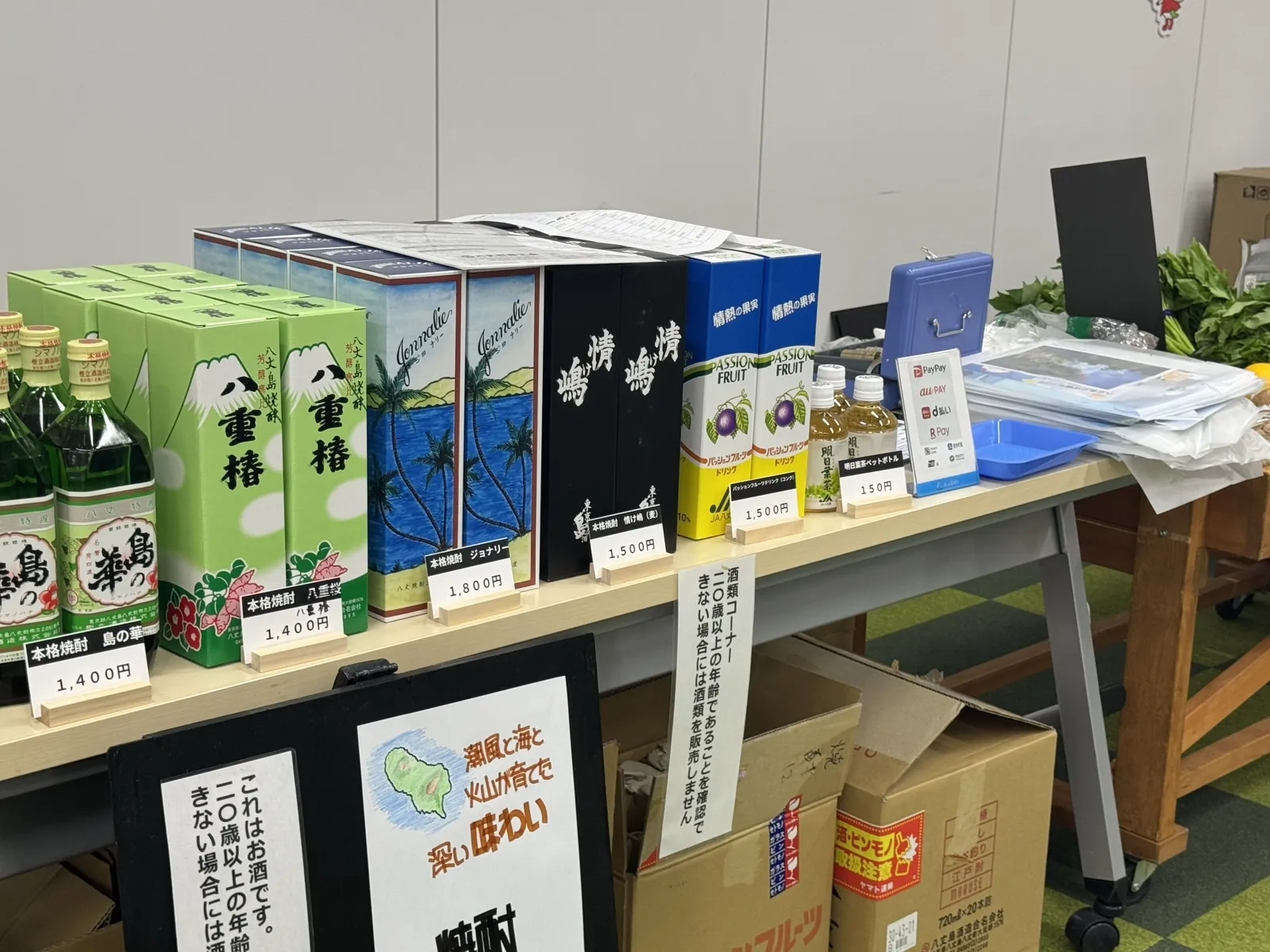 焼酎などの商品と値札が並ぶ売り場の机